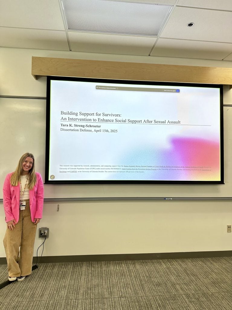 Tara Streng-Schroeter standing in front of her dissertation defense presentation