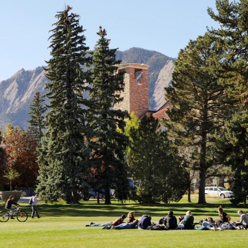 Class outdoors under trees and Flatirons