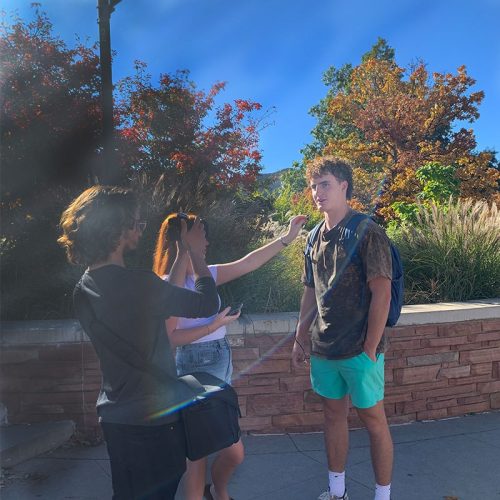 Student being interviewed outside on campus with filmmaker present.