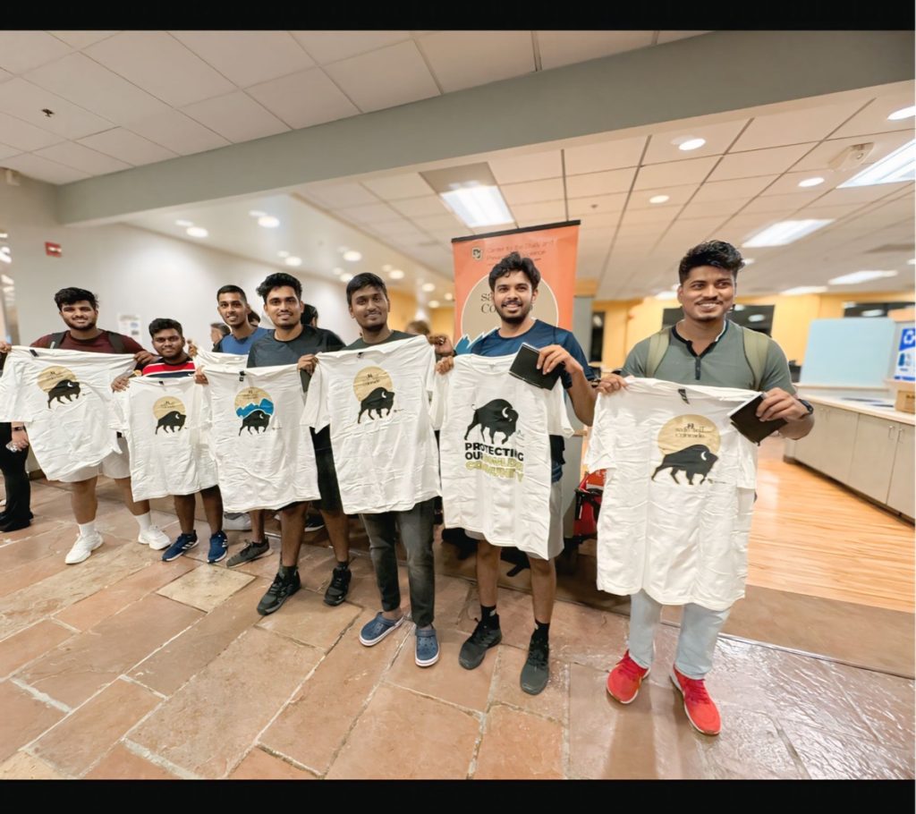 Seven Middle Eastern men stand holding Safe2Tell t-shirts