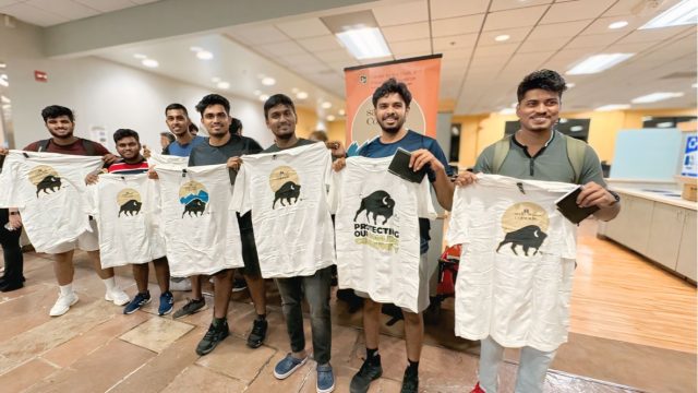 Seven Middle Eastern men stand holding Safe2Tell t-shirts