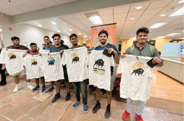 Seven Middle Eastern men stand holding Safe2Tell t-shirts